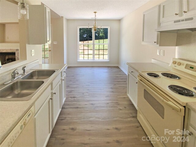 kitchen with hardwood / wood-style floors, sink, decorative light fixtures, a textured ceiling, and white appliances