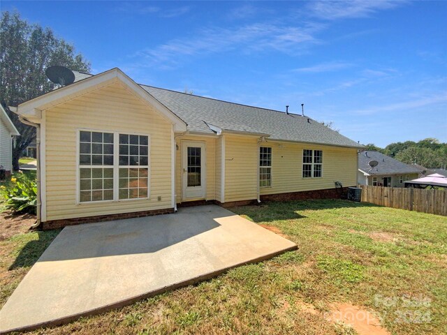 rear view of house with a patio and a yard