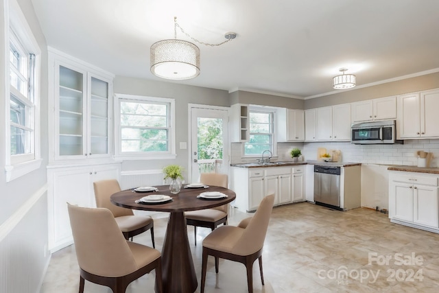 kitchen with white cabinetry, appliances with stainless steel finishes, backsplash, pendant lighting, and sink