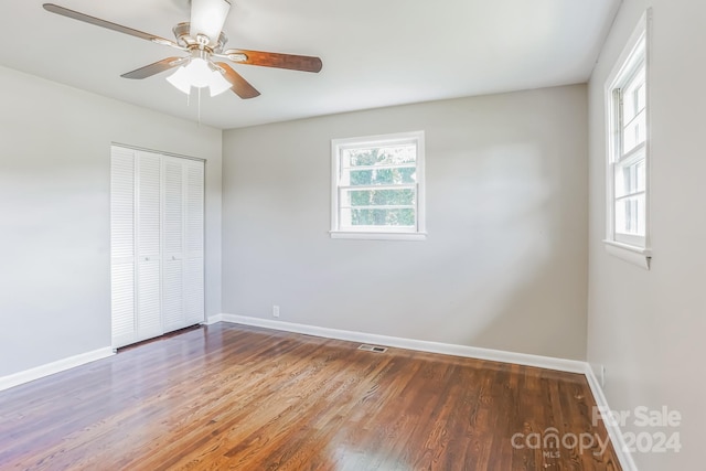 unfurnished bedroom featuring ceiling fan, a closet, and wood-type flooring