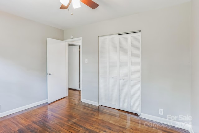 unfurnished bedroom featuring ceiling fan, a closet, and dark hardwood / wood-style flooring