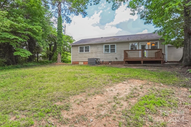 rear view of property with central AC unit, a wooden deck, and a yard