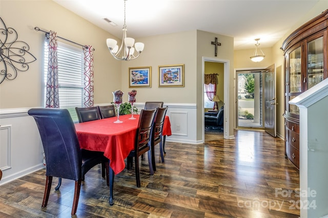 dining area with dark hardwood / wood-style floors and a notable chandelier