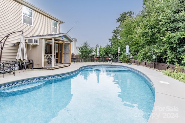 view of pool featuring a patio and a wall unit AC