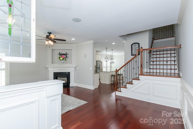 entryway featuring crown molding, dark hardwood / wood-style flooring, and ceiling fan with notable chandelier