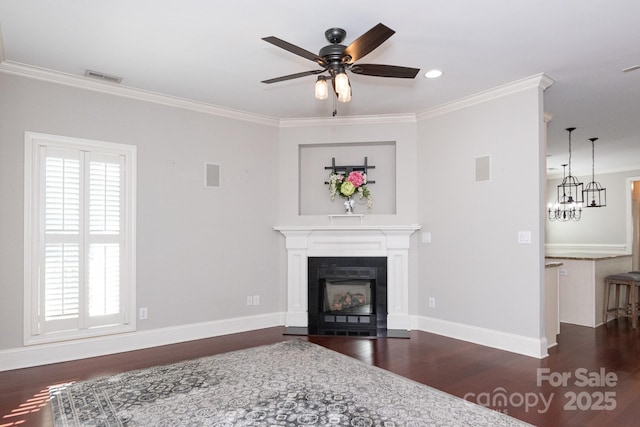 living room with ceiling fan with notable chandelier, dark hardwood / wood-style flooring, and ornamental molding