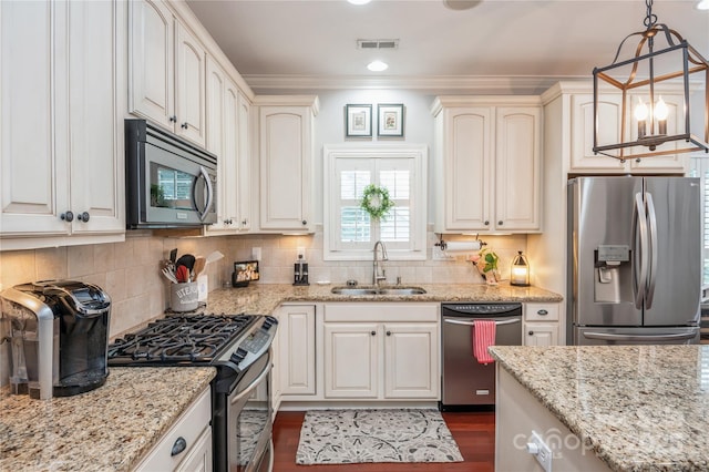 kitchen featuring pendant lighting, backsplash, stainless steel appliances, and sink