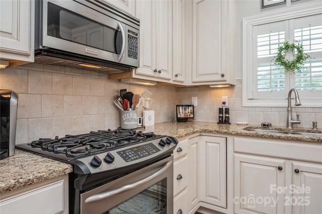 kitchen featuring white cabinets, backsplash, sink, and stainless steel appliances