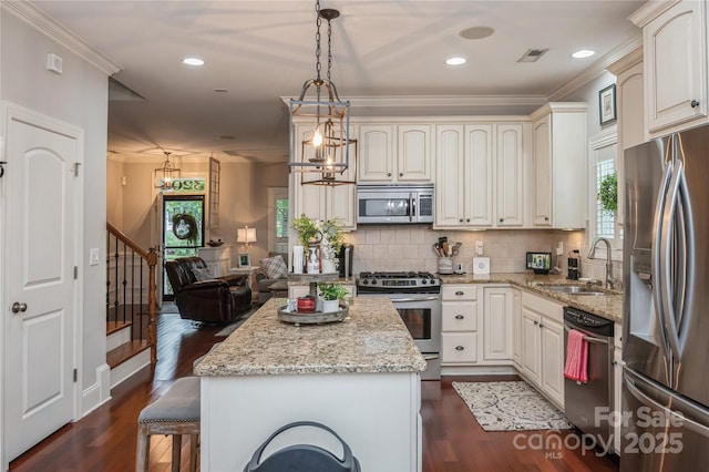 kitchen featuring light stone countertops, sink, dark wood-type flooring, hanging light fixtures, and stainless steel appliances