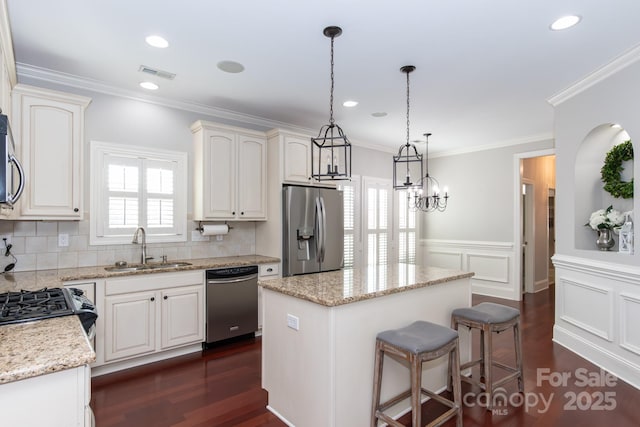 kitchen featuring white cabinets, a kitchen island, sink, and stainless steel appliances