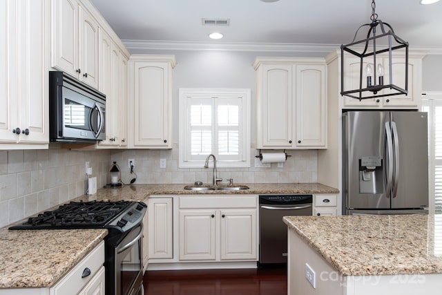 kitchen featuring light stone counters, stainless steel appliances, sink, decorative light fixtures, and white cabinetry