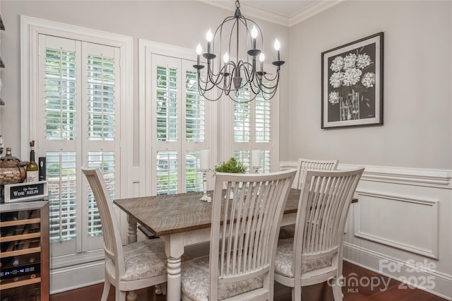 dining area with dark wood-type flooring, crown molding, beverage cooler, and an inviting chandelier