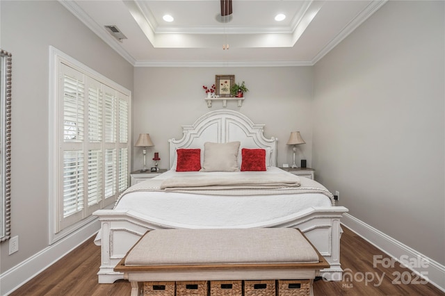 bedroom featuring dark hardwood / wood-style floors, a raised ceiling, and ornamental molding