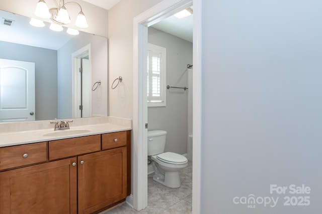 bathroom with a notable chandelier, toilet, and vanity