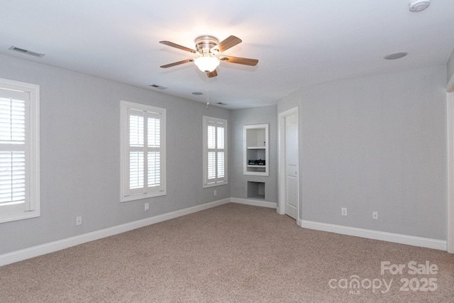 unfurnished room featuring carpet floors, plenty of natural light, and ceiling fan