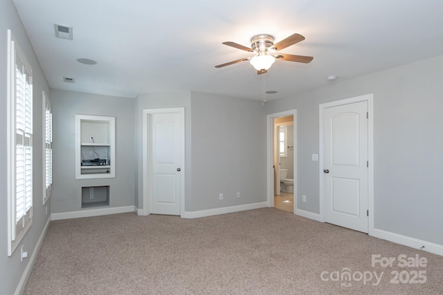 spare room with ceiling fan and light carpet