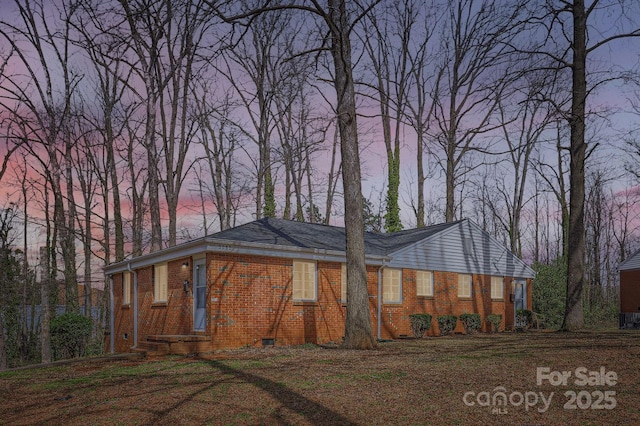 view of property exterior with brick siding and crawl space