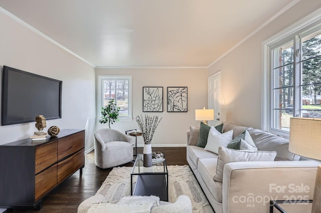 living room featuring ornamental molding, baseboards, a healthy amount of sunlight, and dark wood-type flooring