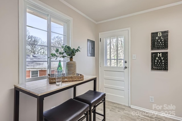 entryway featuring light wood-style floors, electric panel, crown molding, and baseboards