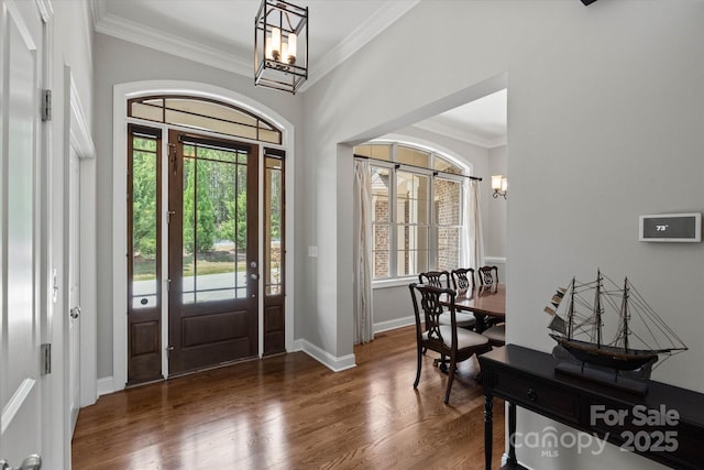 entrance foyer featuring a healthy amount of sunlight, a chandelier, and wood finished floors