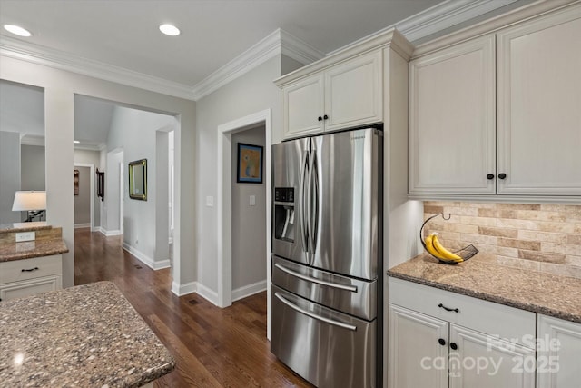 kitchen featuring stone counters, dark wood finished floors, ornamental molding, tasteful backsplash, and stainless steel fridge