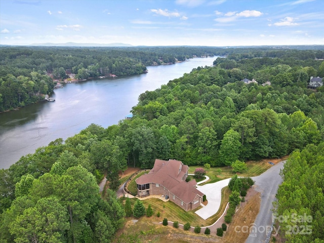 aerial view featuring a forest view and a water view