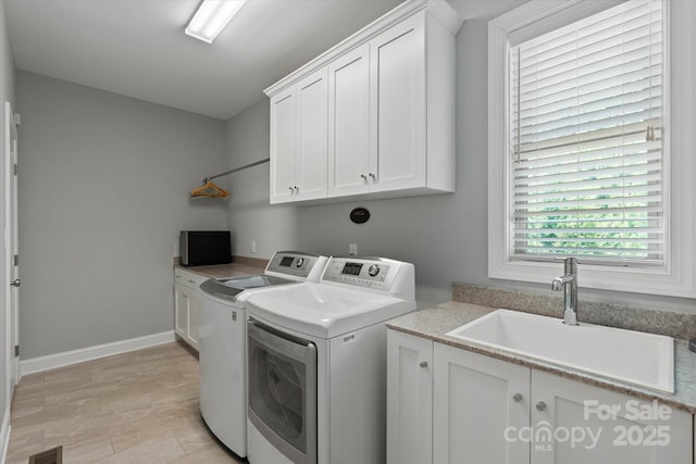 laundry area with a sink, visible vents, baseboards, cabinet space, and washing machine and clothes dryer