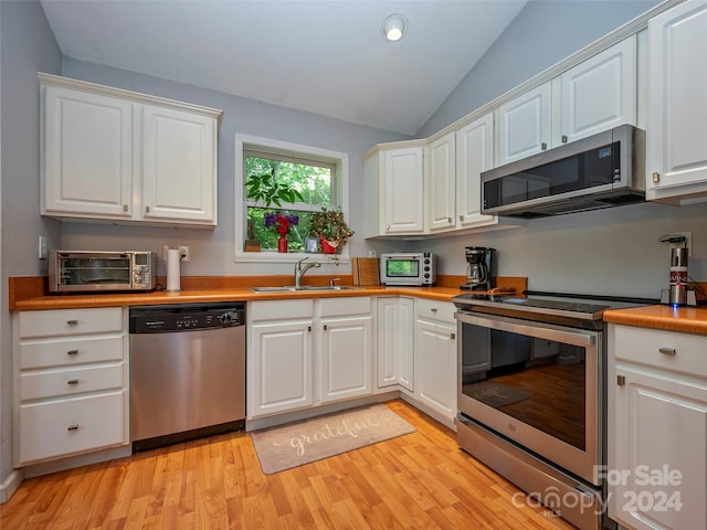 kitchen with appliances with stainless steel finishes, white cabinetry, and sink