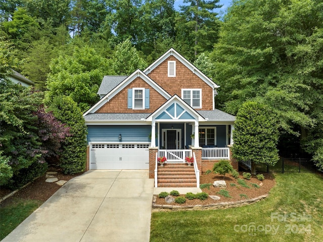 craftsman-style house with a front lawn, covered porch, and a garage