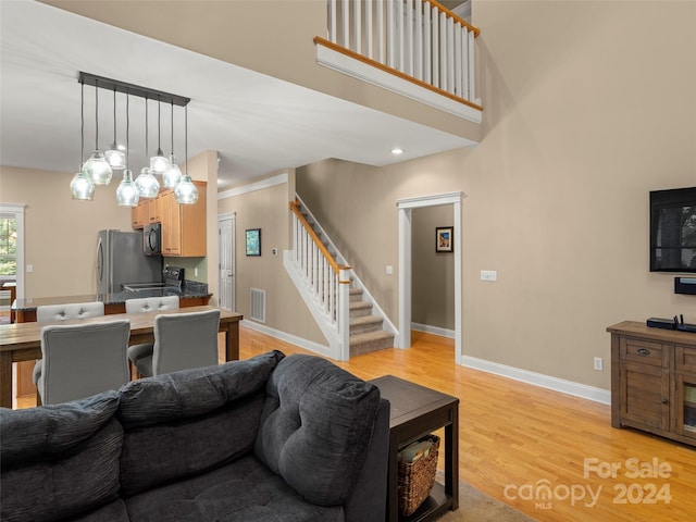 living room with light wood-type flooring and ornamental molding