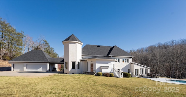 back of property with a garage and a yard