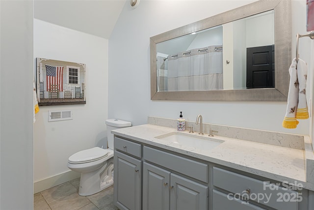 bathroom with toilet, lofted ceiling, tile patterned floors, and vanity