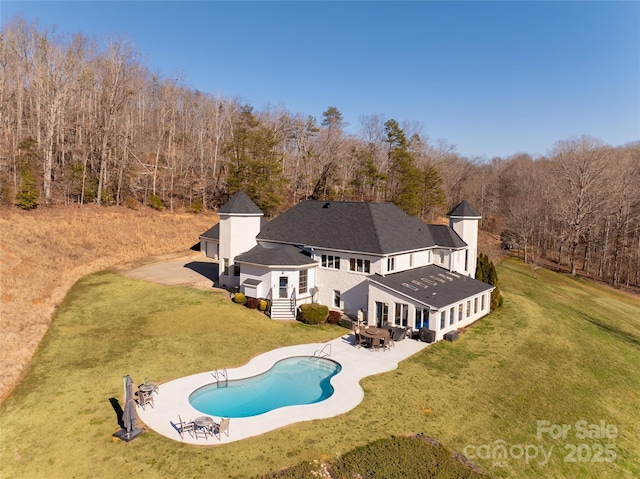 rear view of house featuring a lawn and a patio