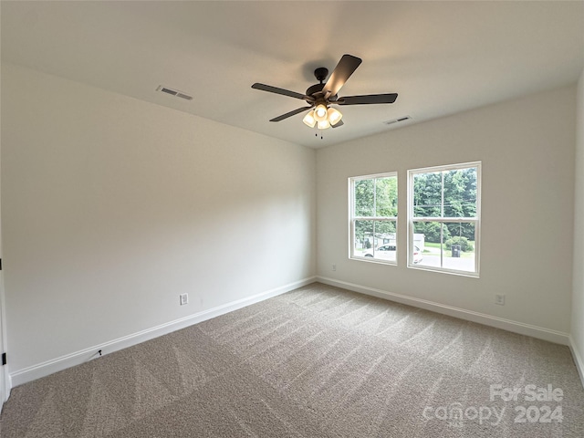 carpeted spare room featuring ceiling fan