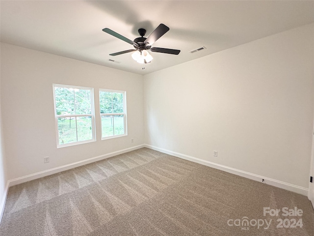 carpeted spare room with ceiling fan