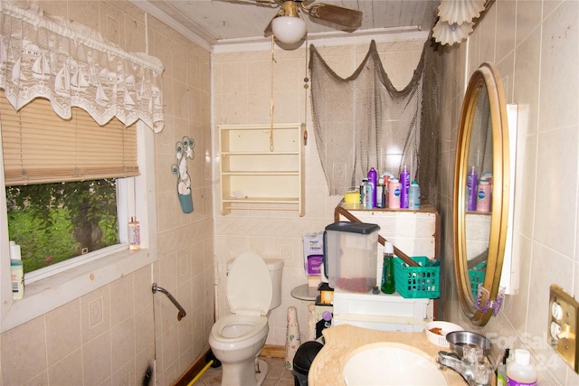 bathroom with sink, ceiling fan, toilet, ornamental molding, and tile walls