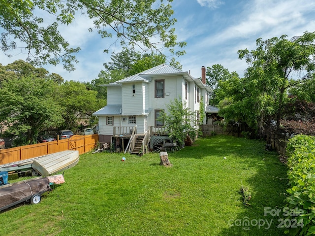 back of house featuring a deck and a lawn