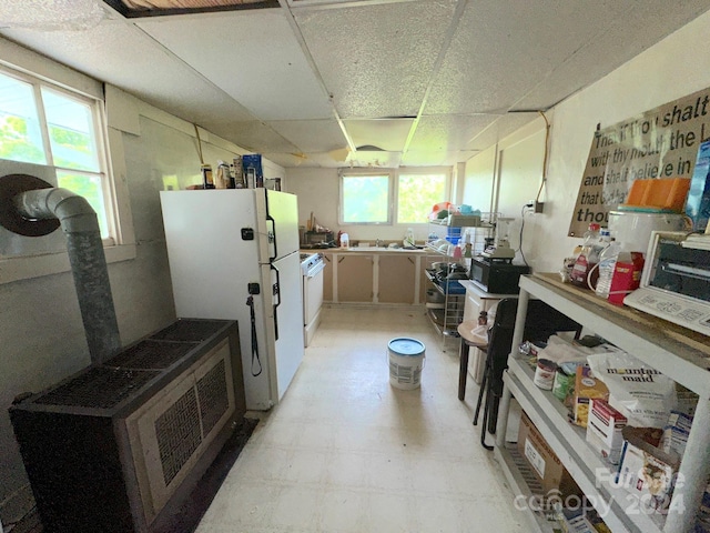 kitchen with a drop ceiling, plenty of natural light, and white appliances