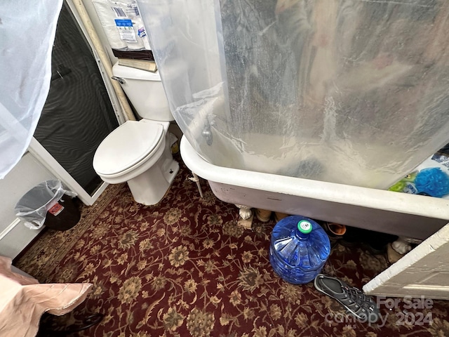 bathroom featuring a tub to relax in and toilet