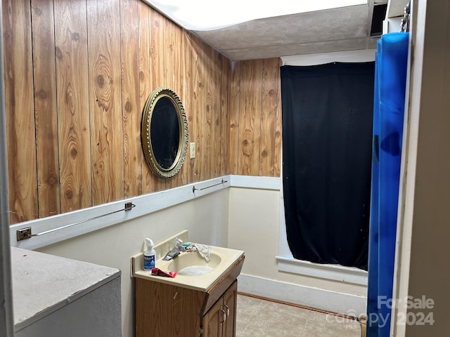 bathroom featuring vanity and wooden walls