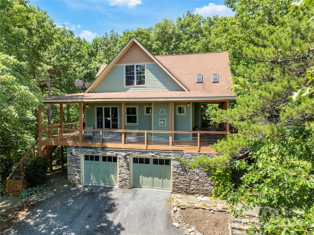 view of front facade featuring a garage, stone siding, and driveway