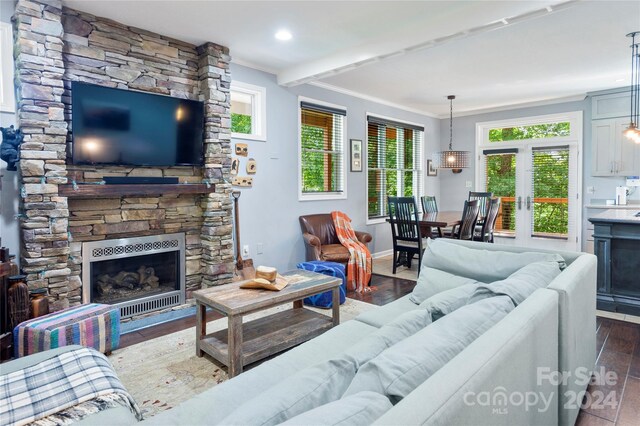 living room with french doors, a fireplace, dark hardwood / wood-style flooring, and crown molding