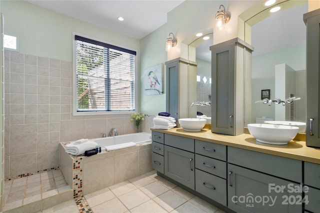 full bath featuring double vanity, tile patterned floors, a sink, and ornate columns