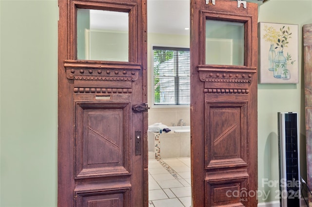 bathroom with tiled bath and tile patterned floors