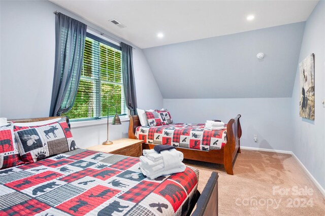 bedroom featuring lofted ceiling, light colored carpet, and multiple windows