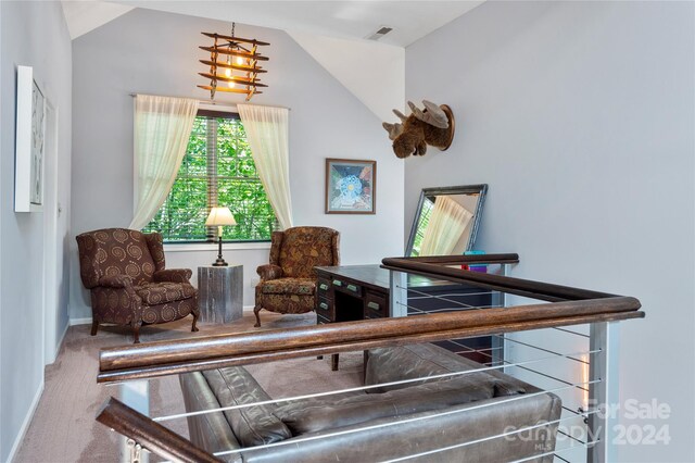 sitting room featuring vaulted ceiling and carpet flooring