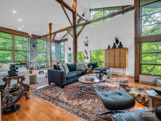 living room with plenty of natural light, high vaulted ceiling, and hardwood / wood-style flooring