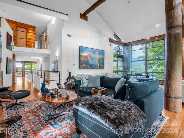 living room featuring hardwood / wood-style flooring, high vaulted ceiling, and plenty of natural light