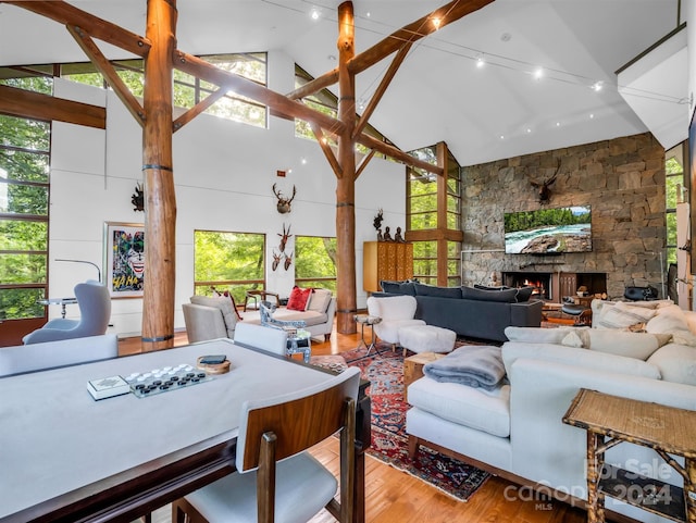 living room featuring a fireplace, high vaulted ceiling, and hardwood / wood-style floors