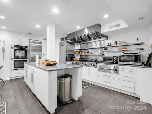 kitchen featuring white cabinetry, a kitchen island, extractor fan, and appliances with stainless steel finishes